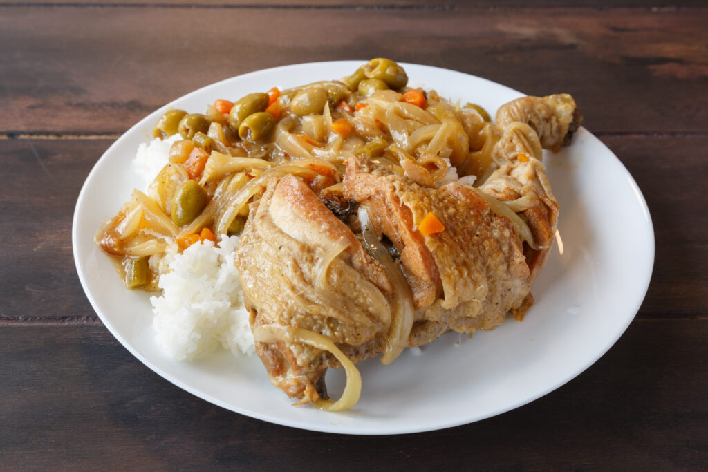 Plat traditionnel de poulet Yassa, mariné au citron et oignons, accompagné de riz.